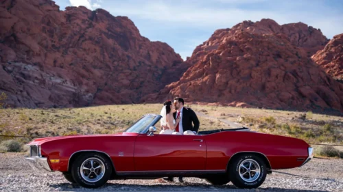 Newlyweds in a red 1970 Buick GS convertible at Red Rock Canyon, Las Vegas wedding